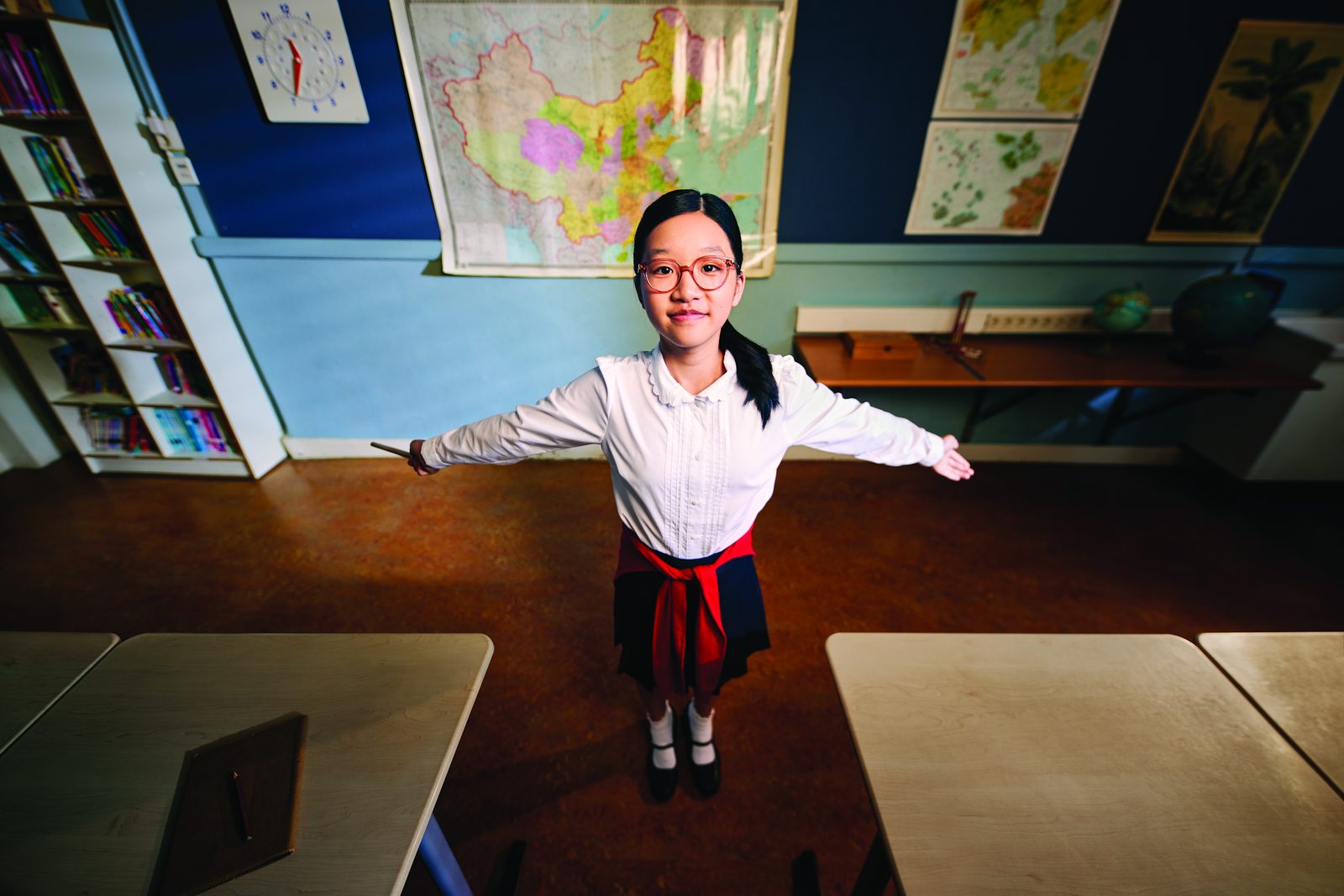 A girl in MiYOSMART spectacles standing at the front of her classroom
