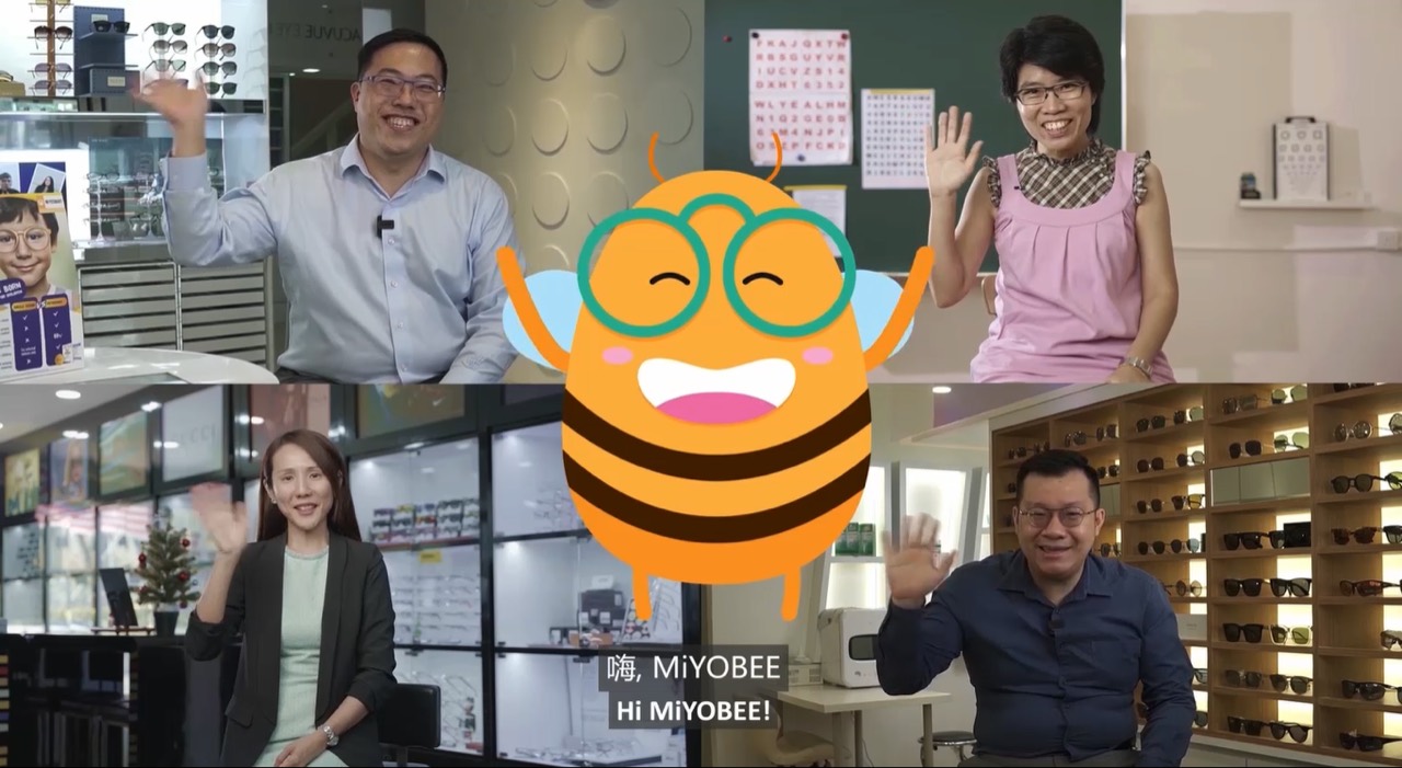 Four Malaysian eye care practitioners waving to camera in their practices